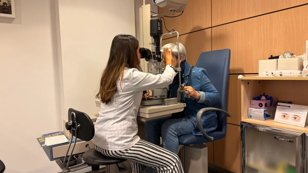 Optometrist examining a patient with a slit lamp