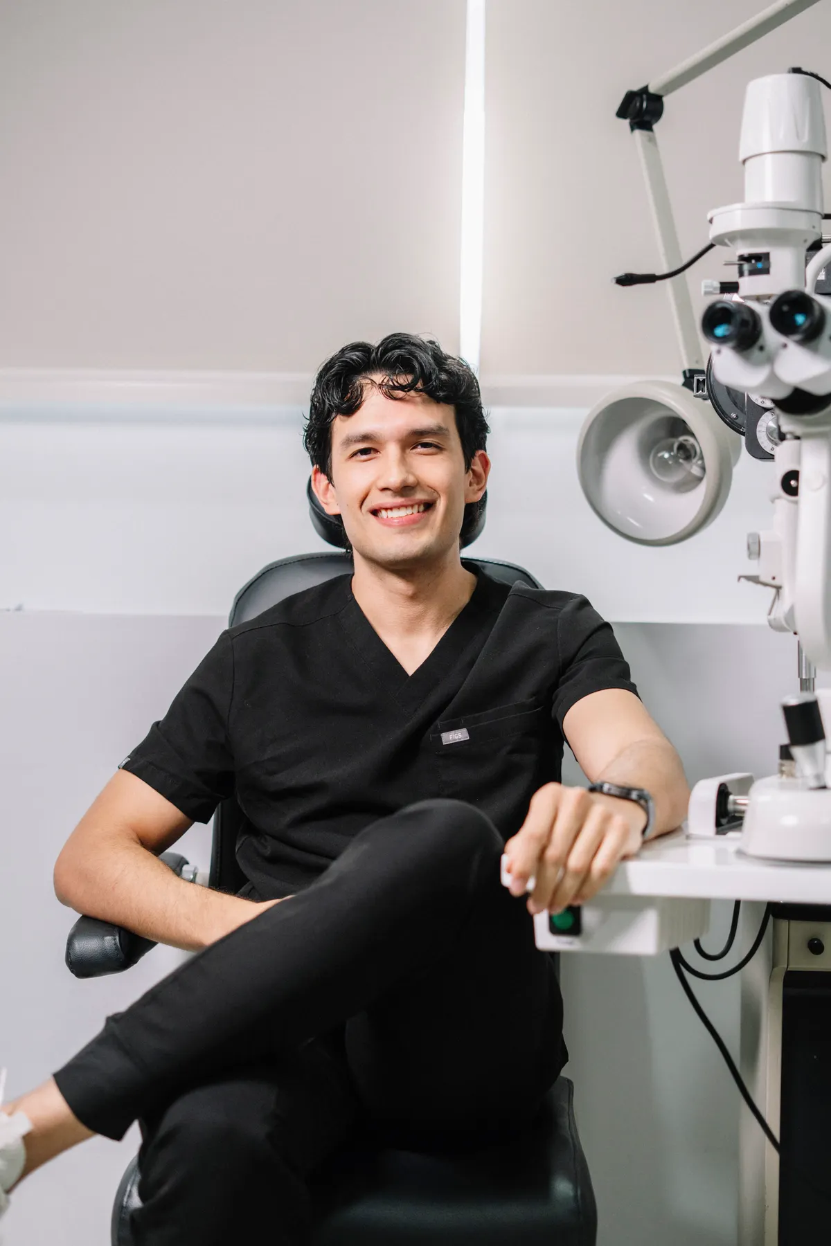 Optometrist sitting beside eye examination equipment
