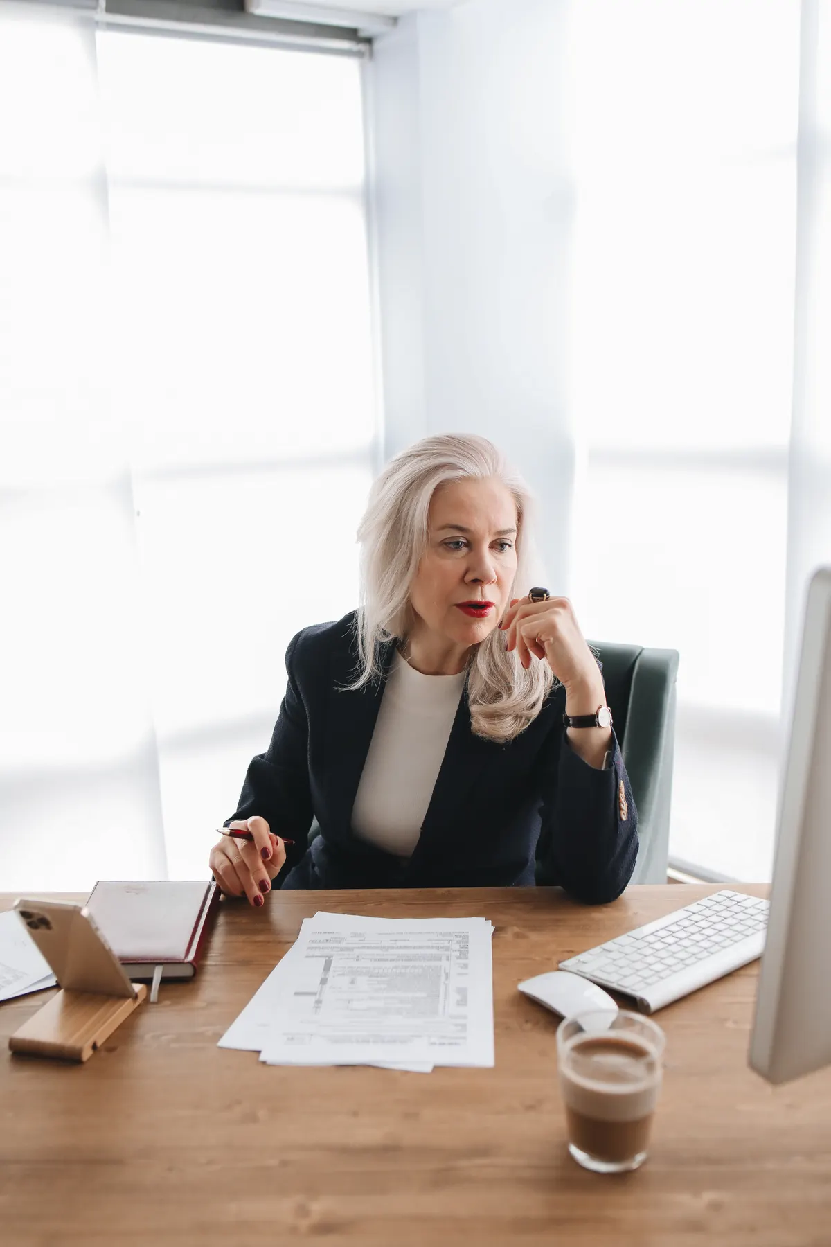 Woman speaking on the phone with documents on her desk