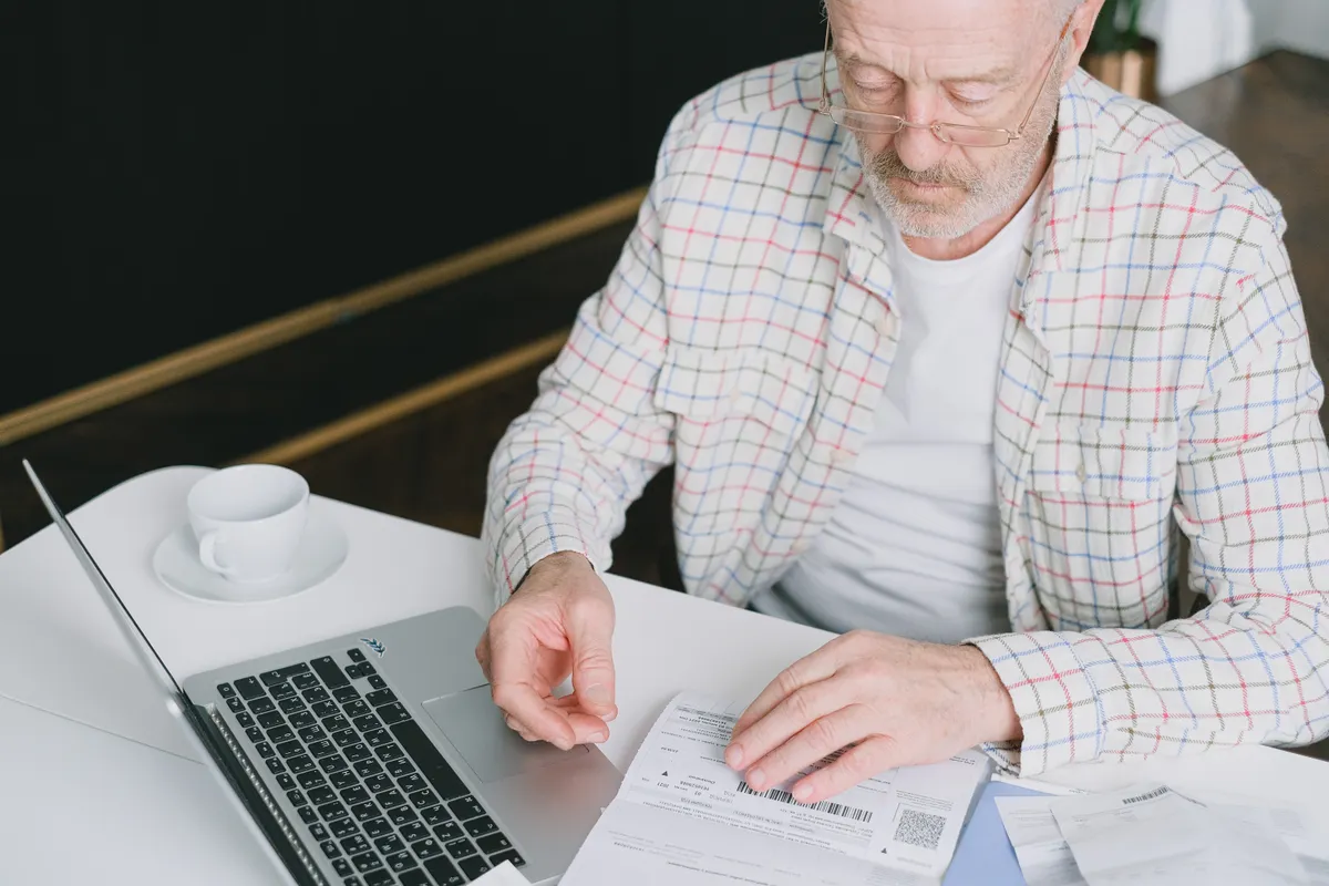 Older man reading documents at a table