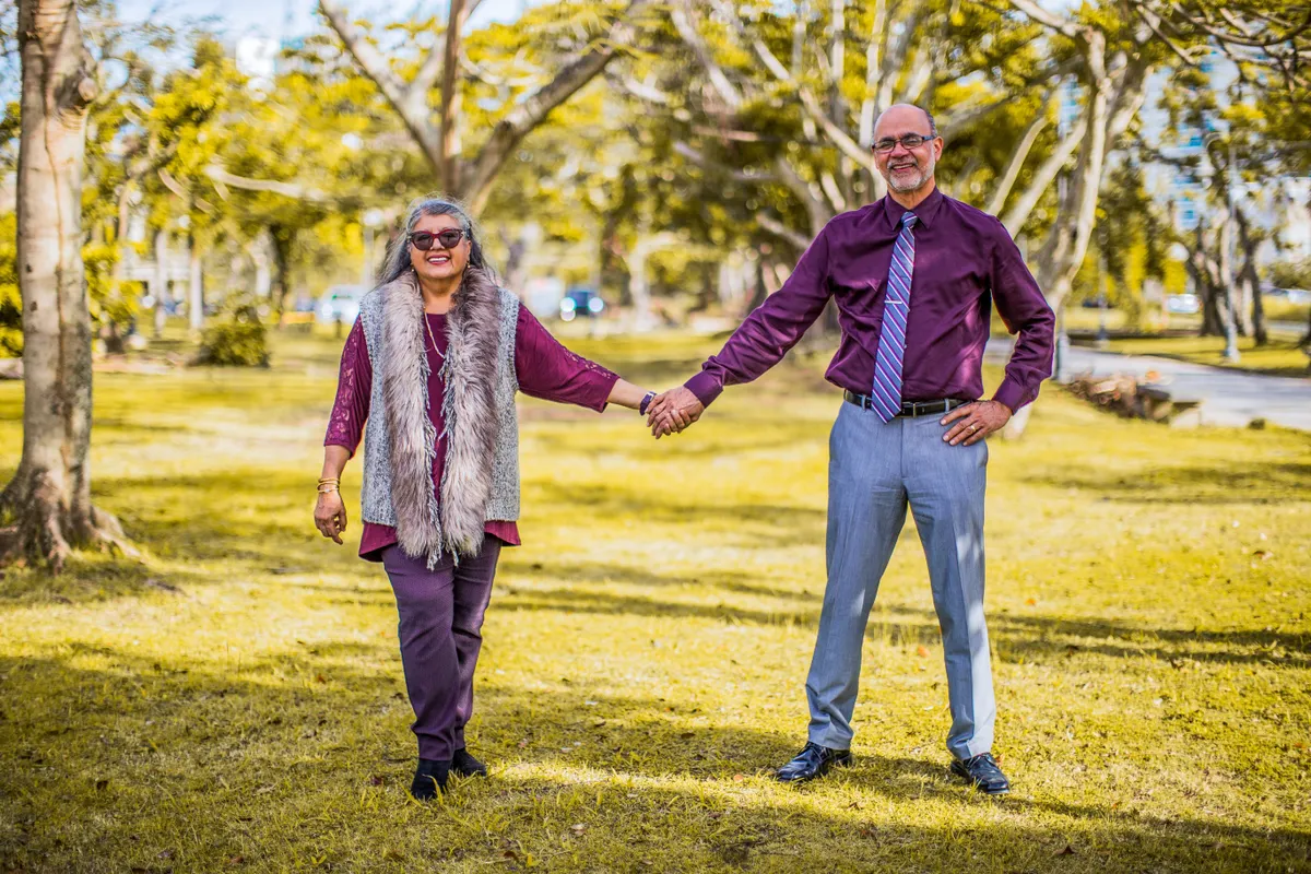 Older couple holding hands in a sunny park