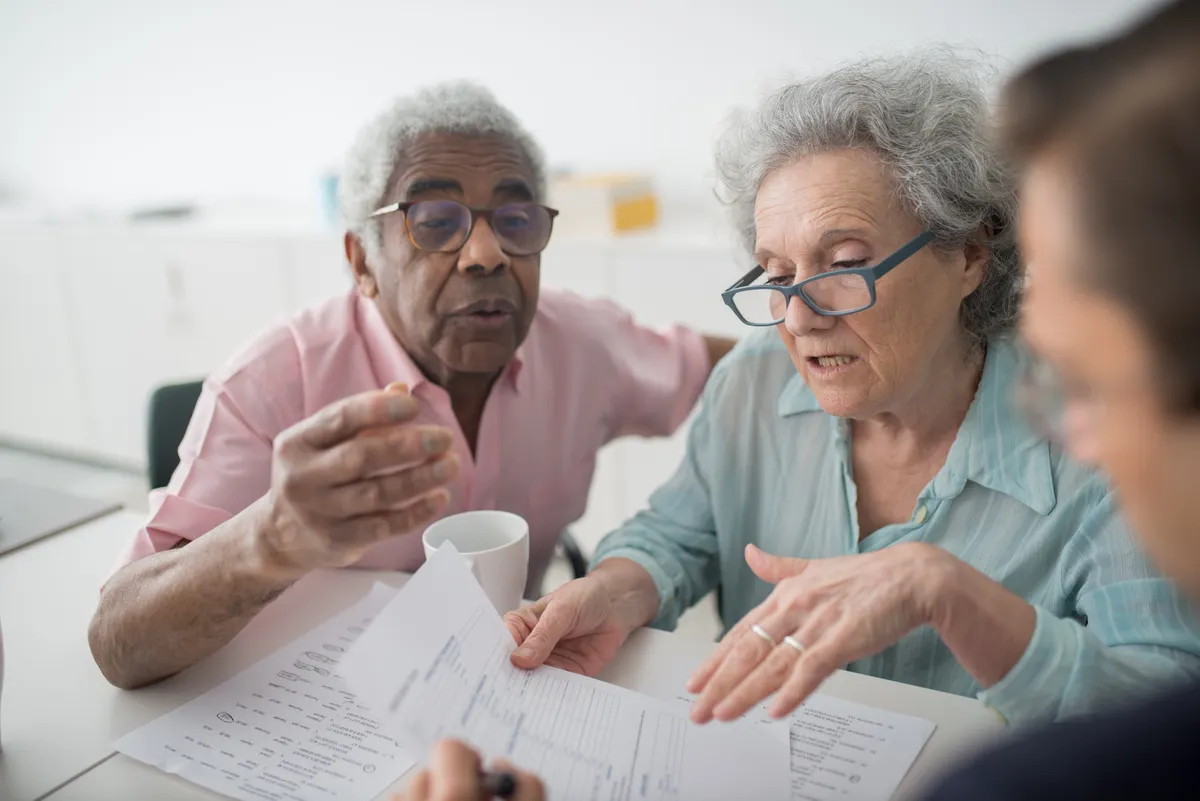 Older couple discussing documents at a desk