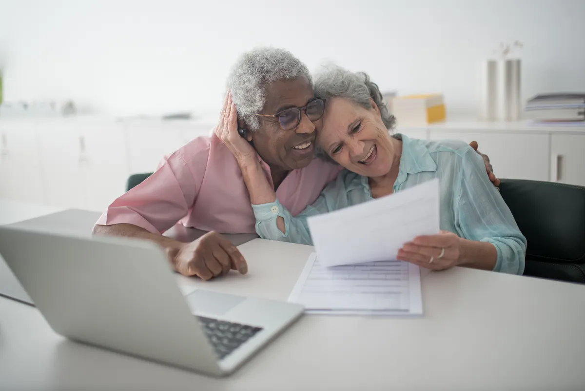 Older couple sharing a document beside a laptop