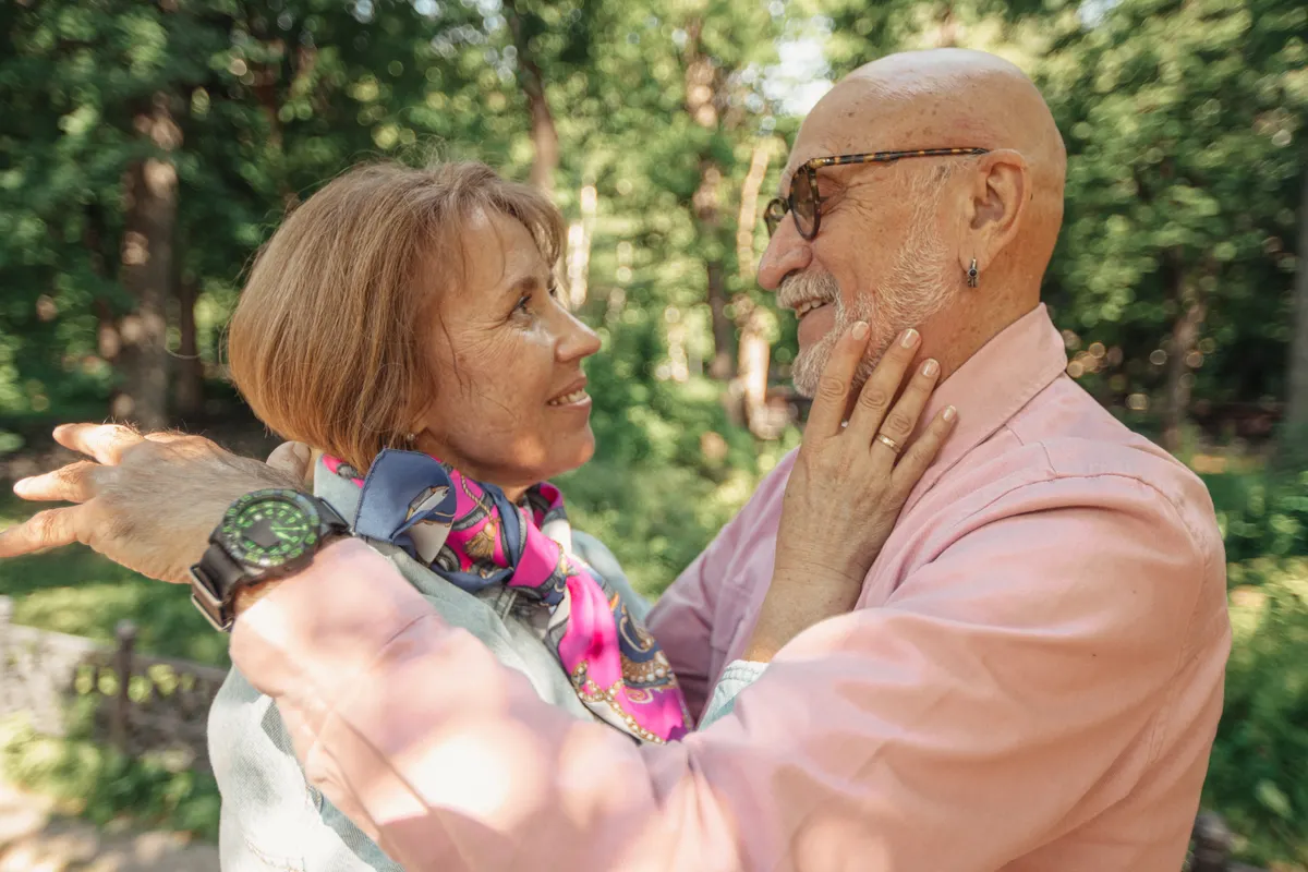 Older couple smiling at each other outdoors
