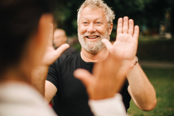 A cheerful man with a beard wearing a black t-shirt, giving a high-five to another person. The image is part of an article discussing the billing and insurance workflow for sleep apnea oral appliances.