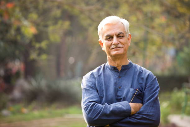 An elderly man standing outdoors with a confident expression, representing the consideration of Medicare coverage for bathroom safety equipment and accessories.