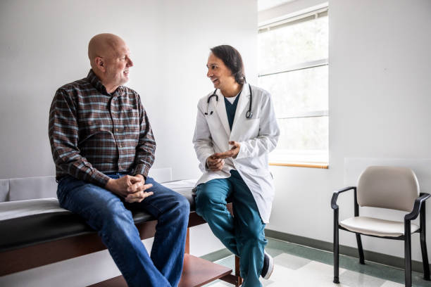 Senior man discussing testosterone replacement therapy (TRT) with a doctor in a medical exam room.