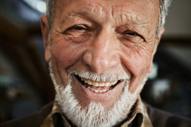 "Close-up of an elderly man smiling warmly, conveying a sense of comfort and reassurance." 